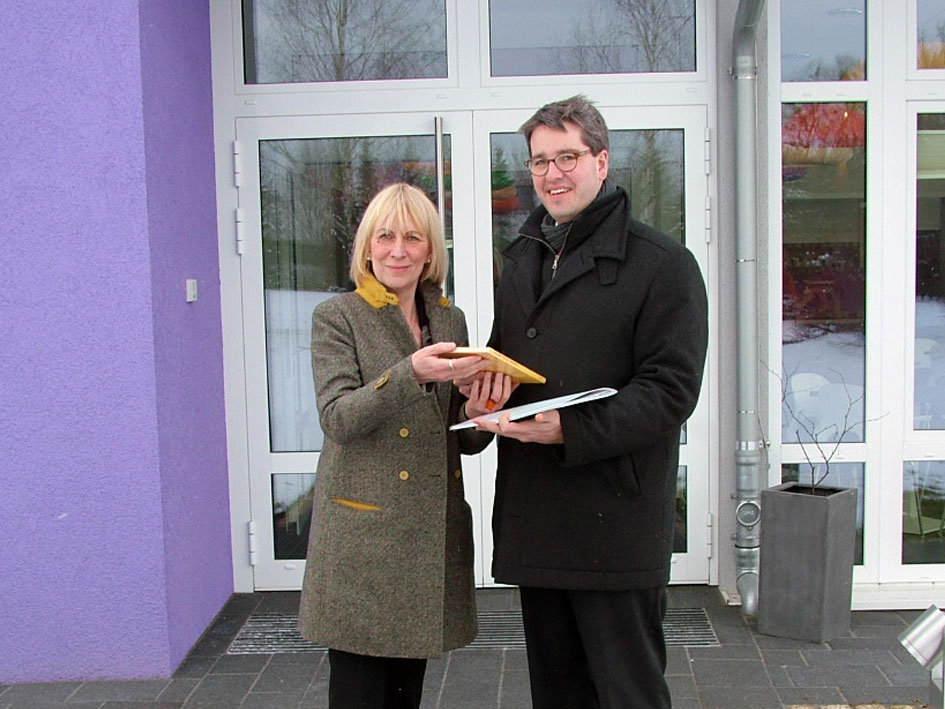 Ein Paar steht vor einem lila Gebäude.