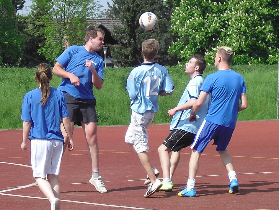 Eine Mannschaft spielt Fußball auf einem offenen Feld.