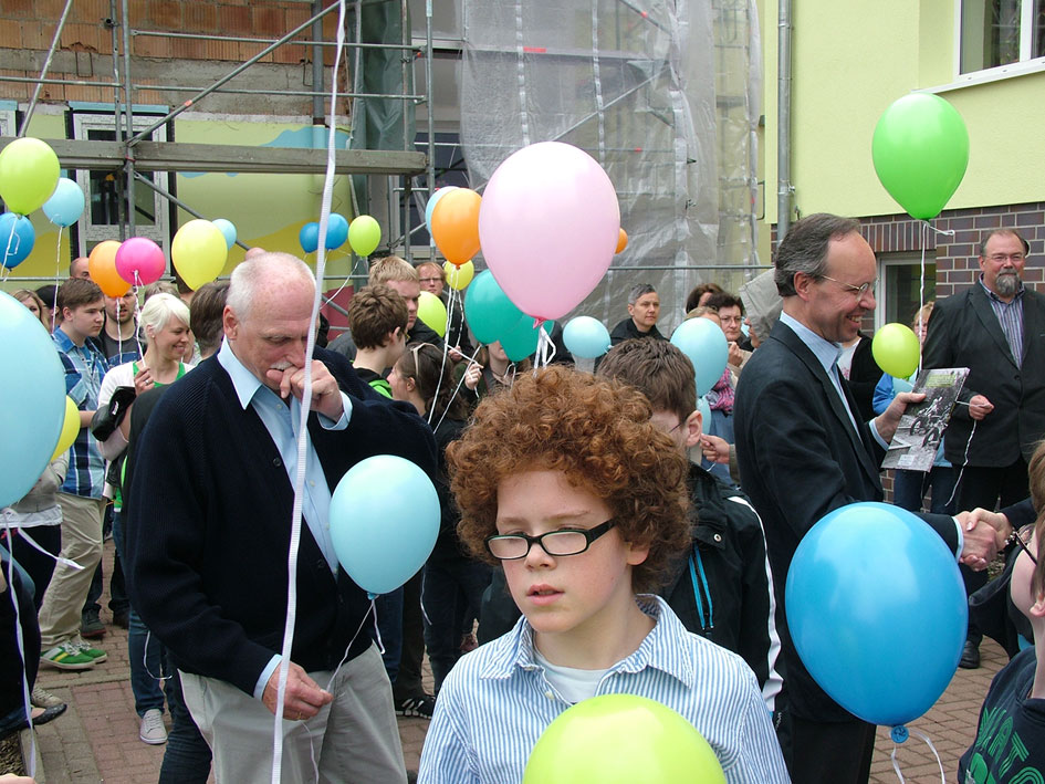 Ein Junge mit vollem, lockigem Haar spielt im Park.