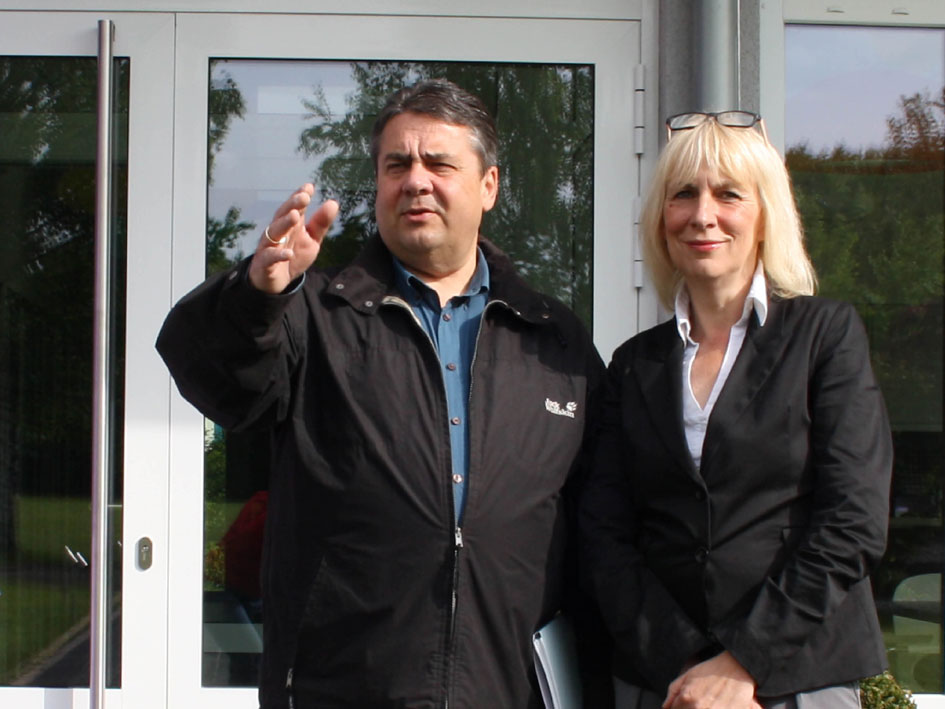 Mann und Frau stehen nebeneinander vor einem Gebäude.