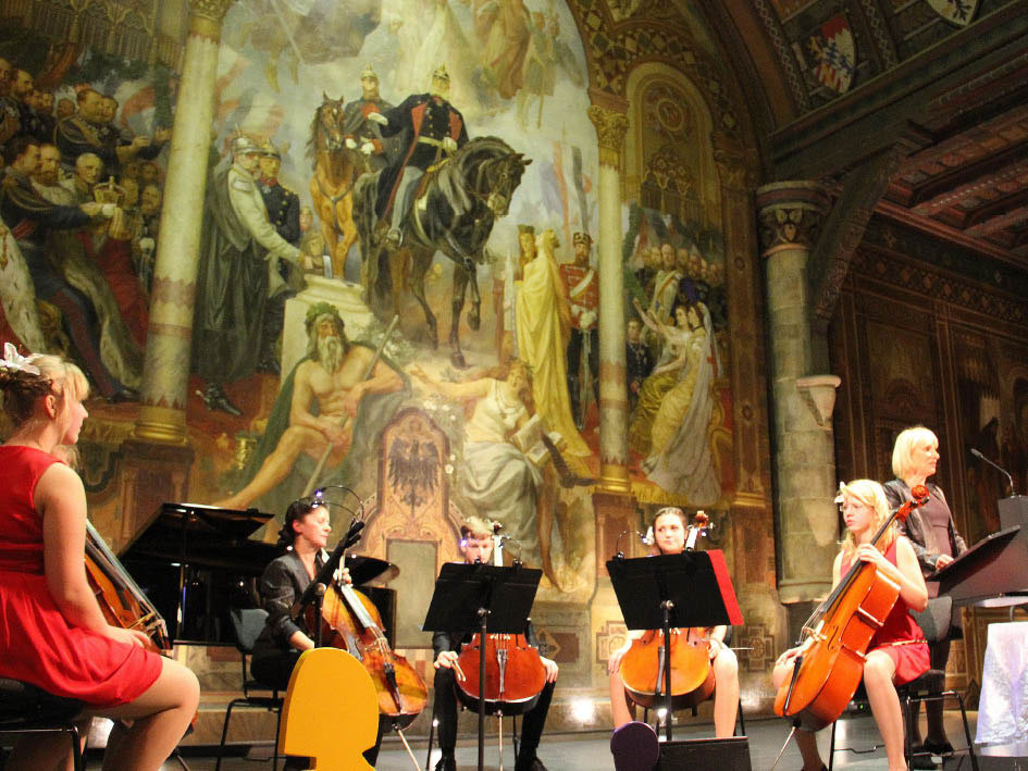 Eine Gruppe von Musikern spielt vor einem Gemälde.