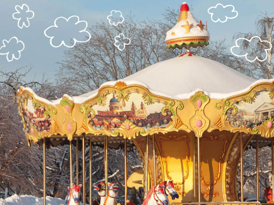 Ein Karussell, das im Schnee steht, umgeben von einer winterlichen Landschaft.