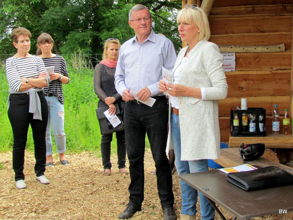 Eine Gruppe von Menschen steht um einen Tisch und diskutiert miteinander.