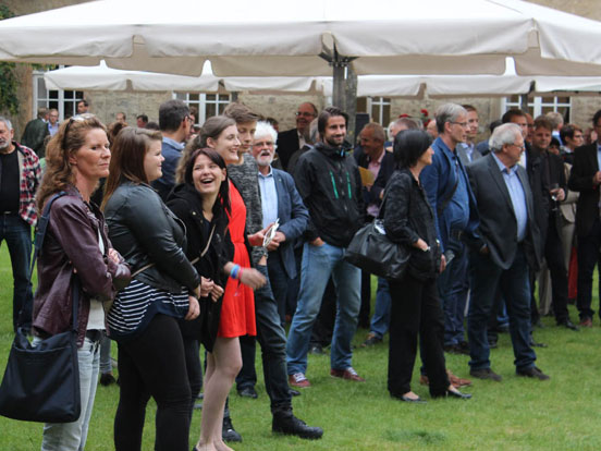 Eine Gruppe von Menschen versammelt sich in einem grünen Feld.