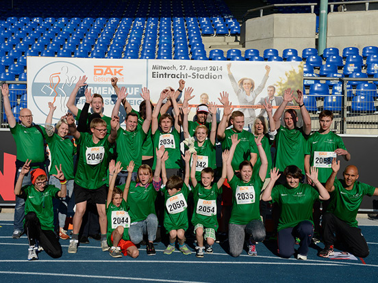 Menschen stehen zusammen und lächeln in die Kamera für ein Bild.