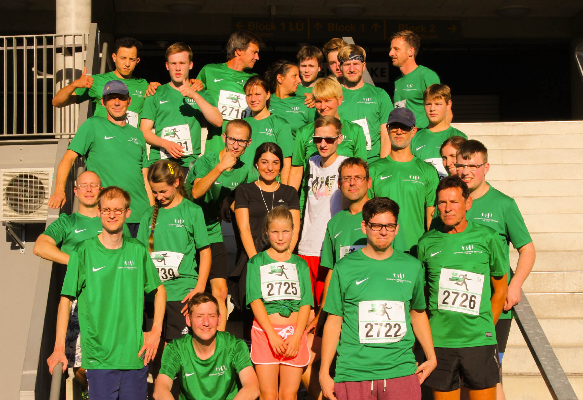 Menschen stehen zusammen und lächeln in die Kamera für ein Bild.