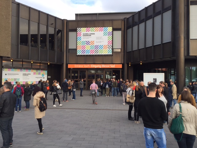 Gruppe von Personen vor einem Gebäude mit auffälligem Schild.