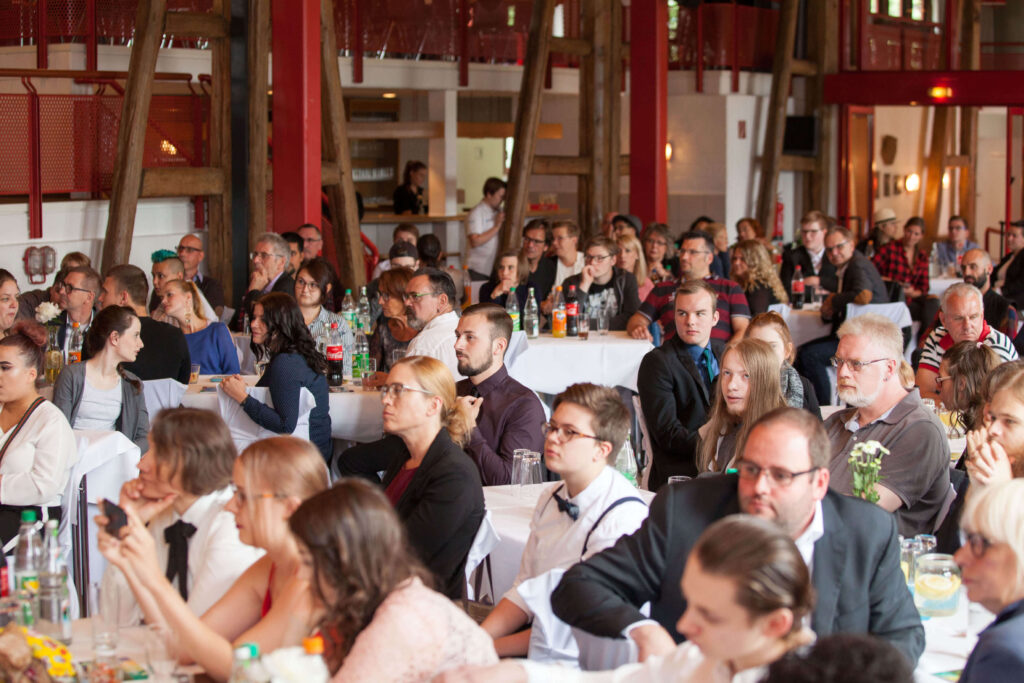 Festliche Veranstaltung: Publikum sitzt an Tischen, lauscht Rede, Konferenz, Hochzeit, Feier, Event, Publikum, Gäste, Saal.