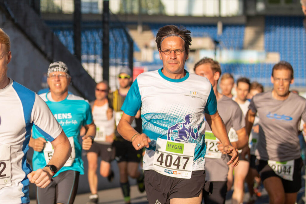 Marathonläufer beim Stadtlauf. Sportliche Männer und Frauen beim Laufwettbewerb, gesunde Lebensweise und Fitness im Fokus.