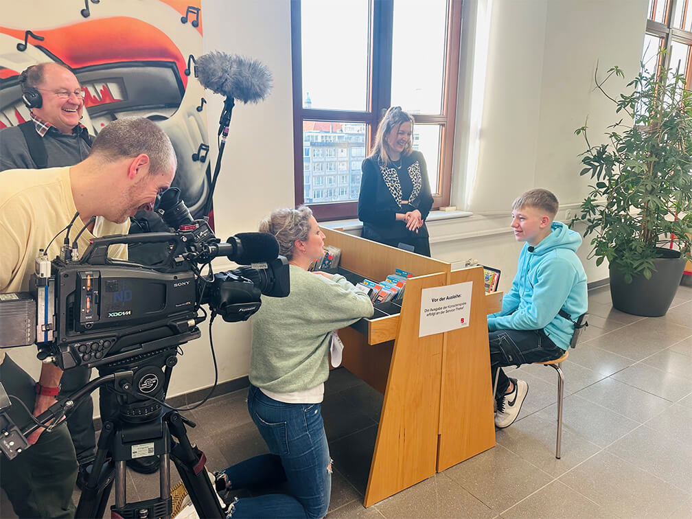 Ein Mann und eine Frau filmen ein Video in einem Raum.