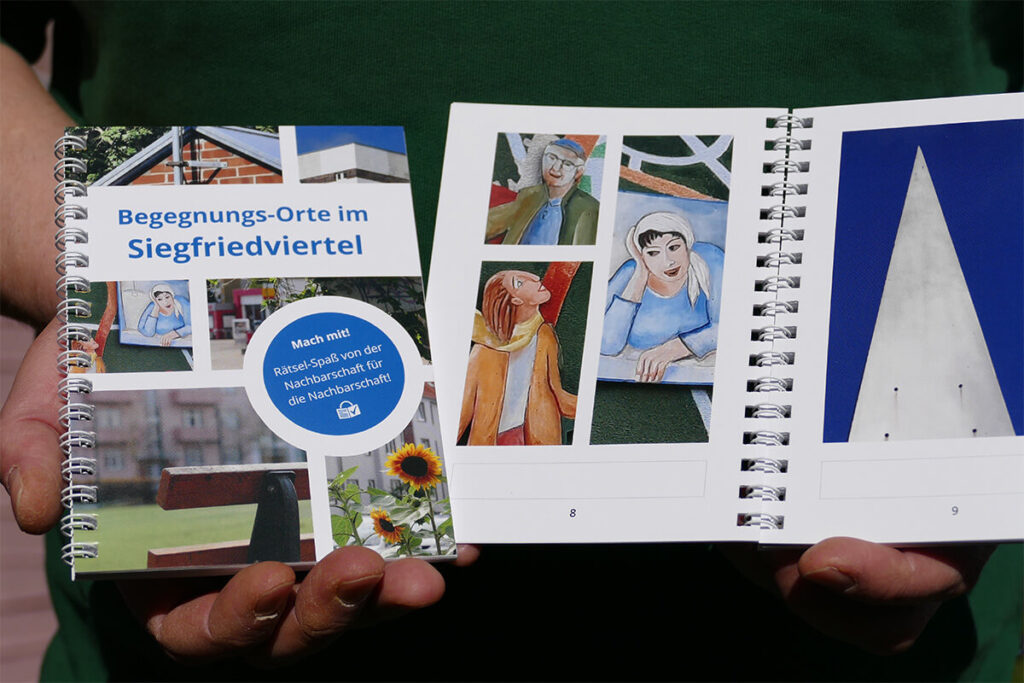 Eine Person hält ein Buch mit Bildern von Gebäuden und Architektur.