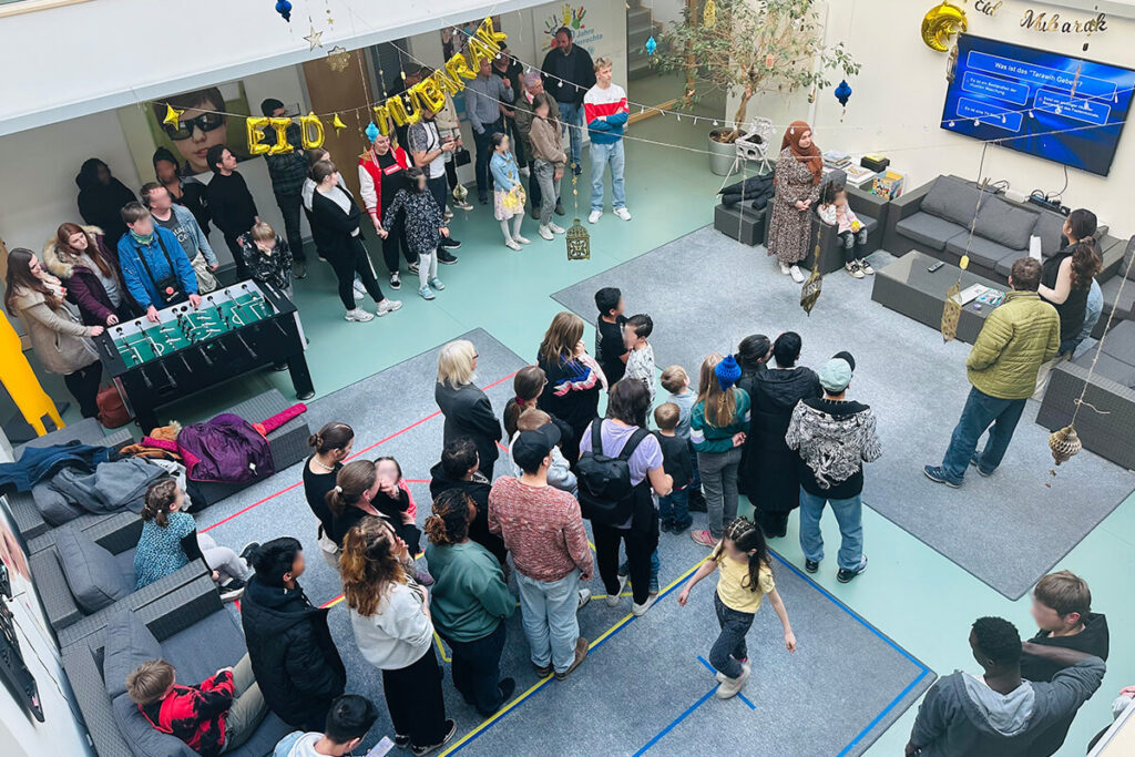 Eine Gruppe von Menschen steht in einem Raum und blickt sich um.