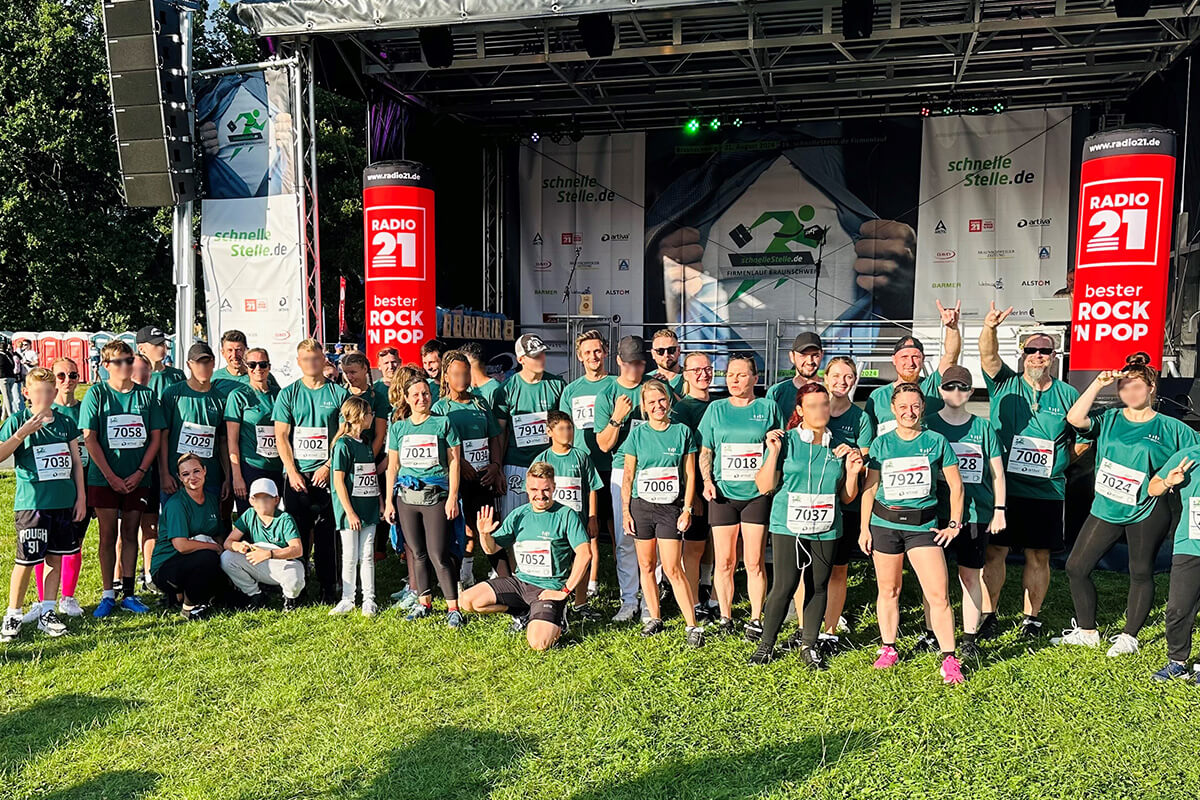 Eine Gruppe von Menschen in grünen Shirts steht auf einer Bühne.