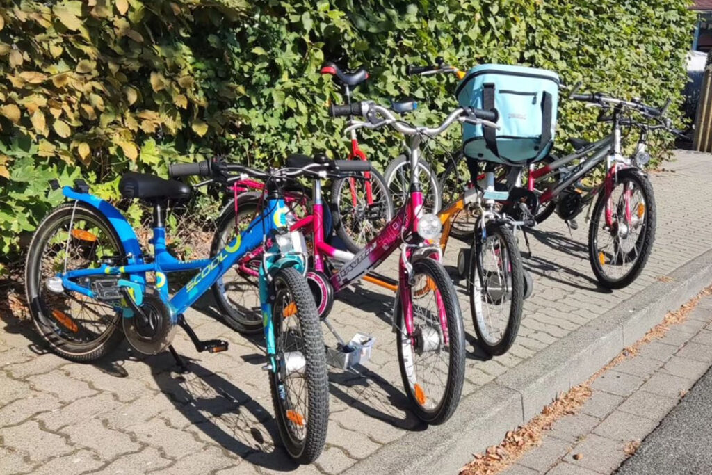 Mehrere Fahrräder sind entlang der Straße abgestellt.