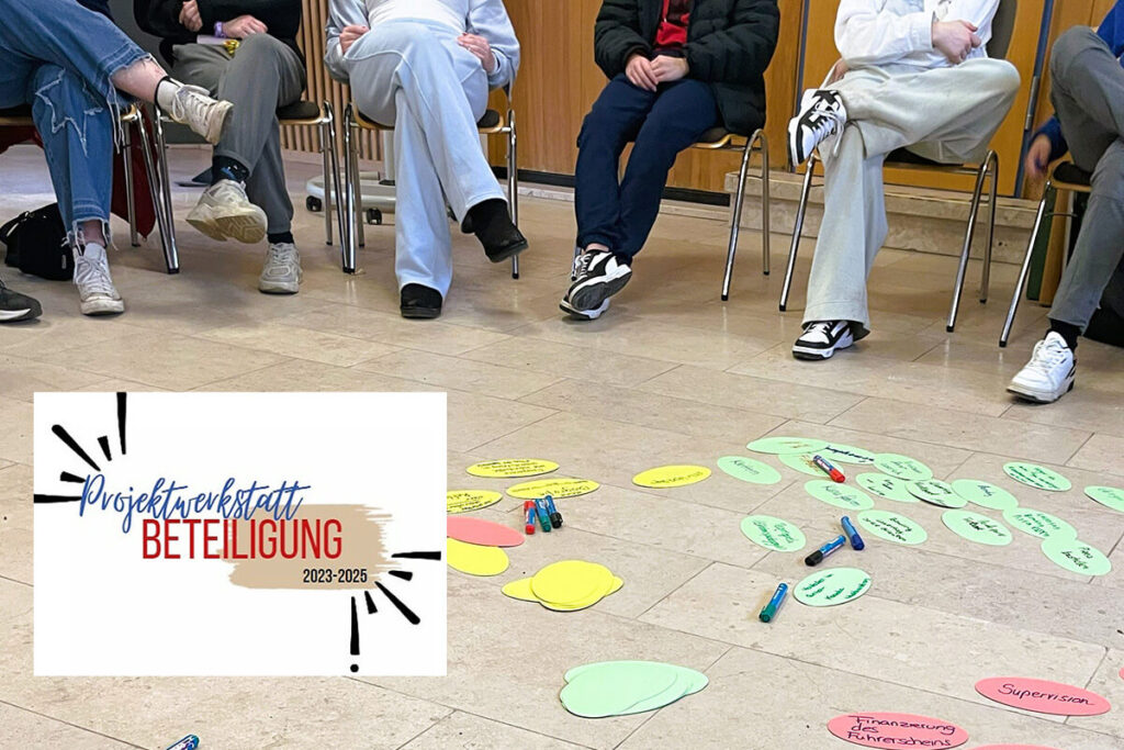 Projektwerkstatt Beteiligung: Workshop-Szene mit Teilnehmern, Bodenkarten und Stiften für Brainstorming & Ideenfindung.