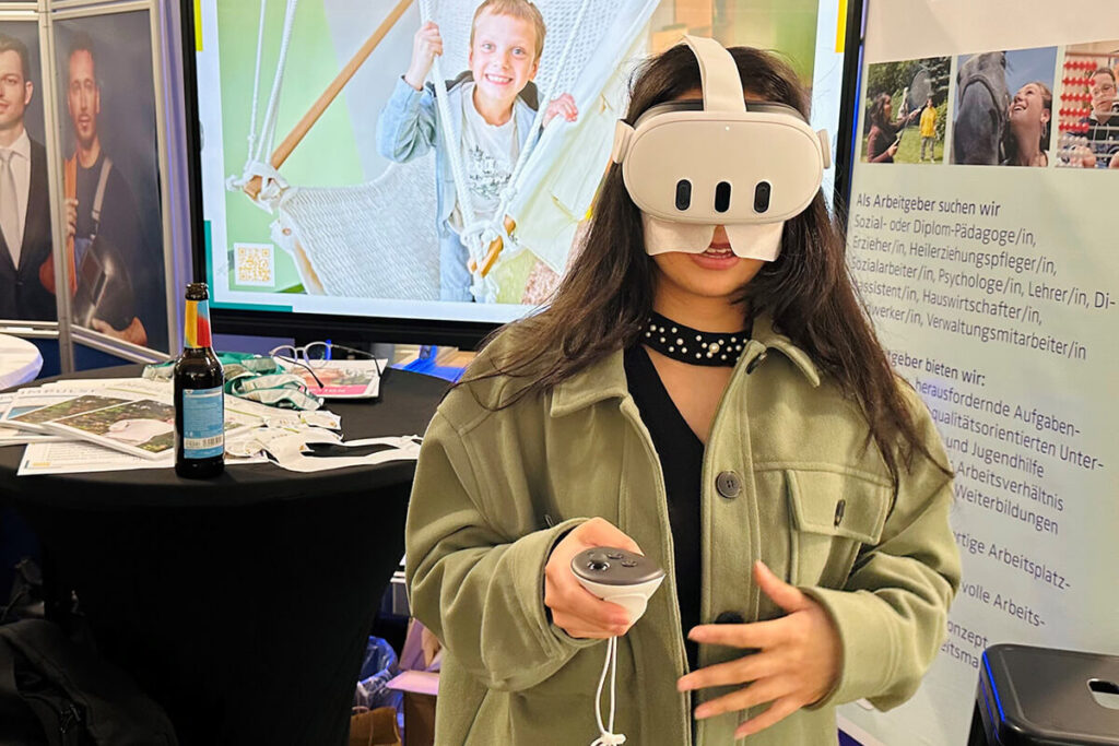 Mädchen mit VR-Brille auf Messe, Jobmesse. Virtuelle Realität erleben. Zukunftsorientierte Technologie für Berufsorientierung und Bildung. Innovation.