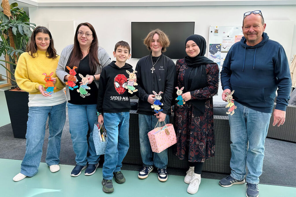 Gruppe von Personen mit selbstgebastelten Osterhasen. Osterdekoration, Osterbasteln mit Kindern, Osterfest, Frühlingsdekoration, Osterhase basteln.