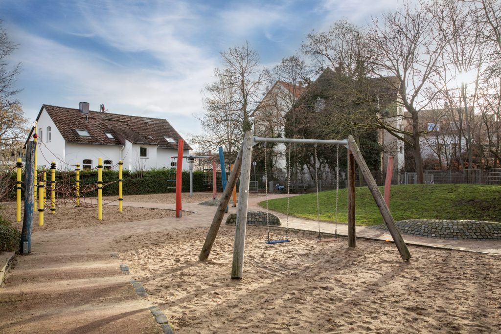 Wohngebiet mit einem Spielplatz, der Schaukeln und eine Schaukelanlage zeigt.