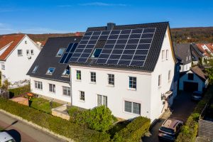 Ein Wohnhaus mit Solarpanelen auf dem Dach zur Nutzung erneuerbarer Energien.