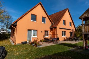 Ein Haus mit orangefarbenen Wänden und einem Holzzaun umgibt die Immobilie.