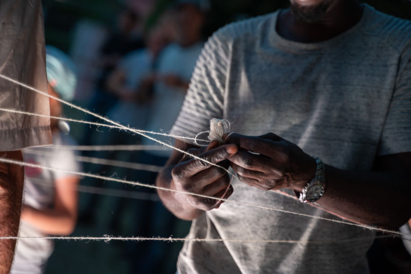 Ein Mann bindet eine Schnur an eine andere Schnur.