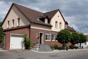 Ein Einfamilienhaus mit Garage und gepflasterter Einfahrt.
