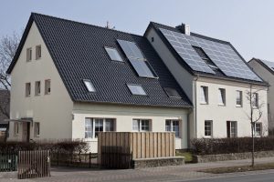 Ein Haus mit Solarpanelen auf dem Dach, das umweltfreundliche Energie erzeugt.