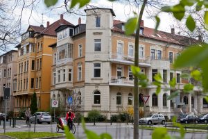 Eine Straße mit mehreren Gebäuden und Bäumen im Hintergrund.